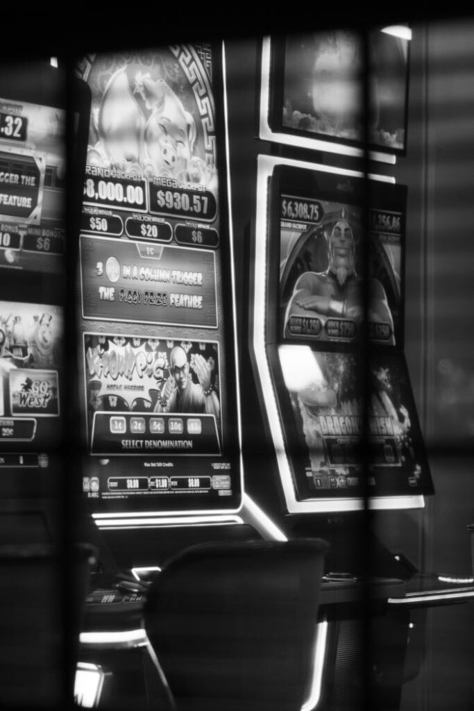 Official Dubibet Entry | Register & Start Live Casino Play. Monochrome image of casino slot machines reflecting lights.
