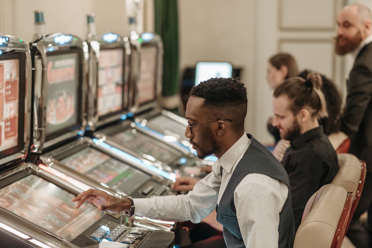 Dubibet Register | Entry & Secure Login for Players. Group of men enjoying an evening at a casino, playing slot machines indoors.