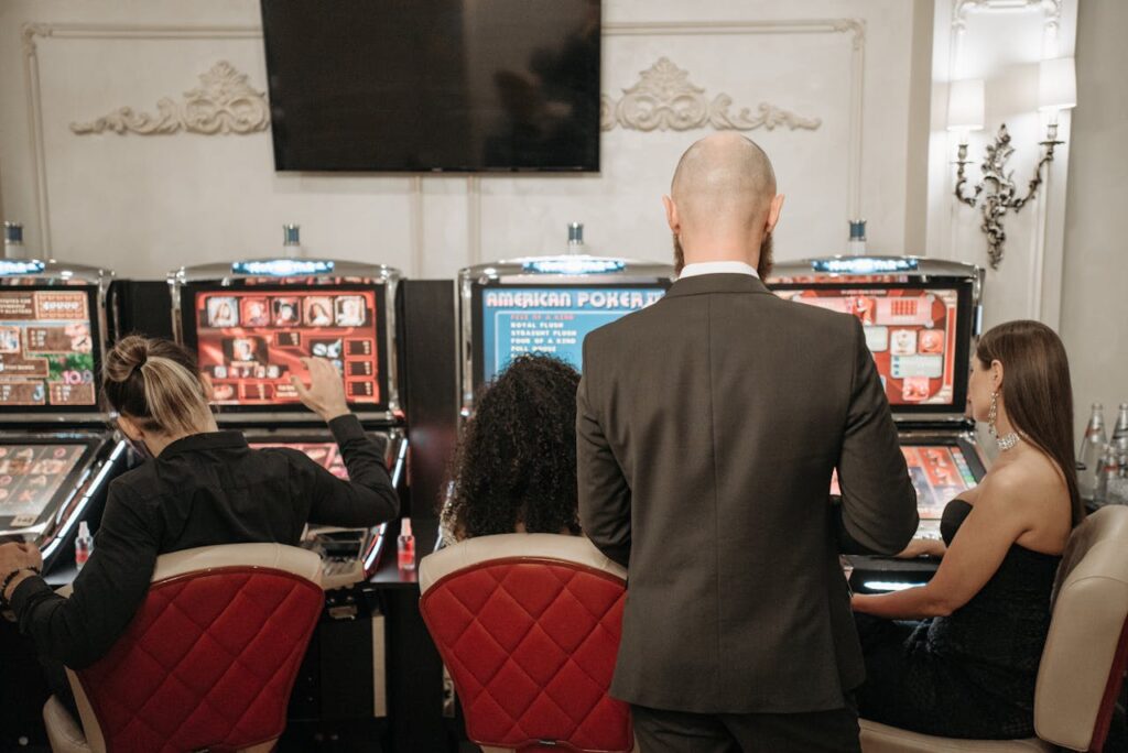 Dubibet Official Login | Instant Access to Casino & Sports. A group of adults engaged in playing slot machines inside a stylish casino setting.