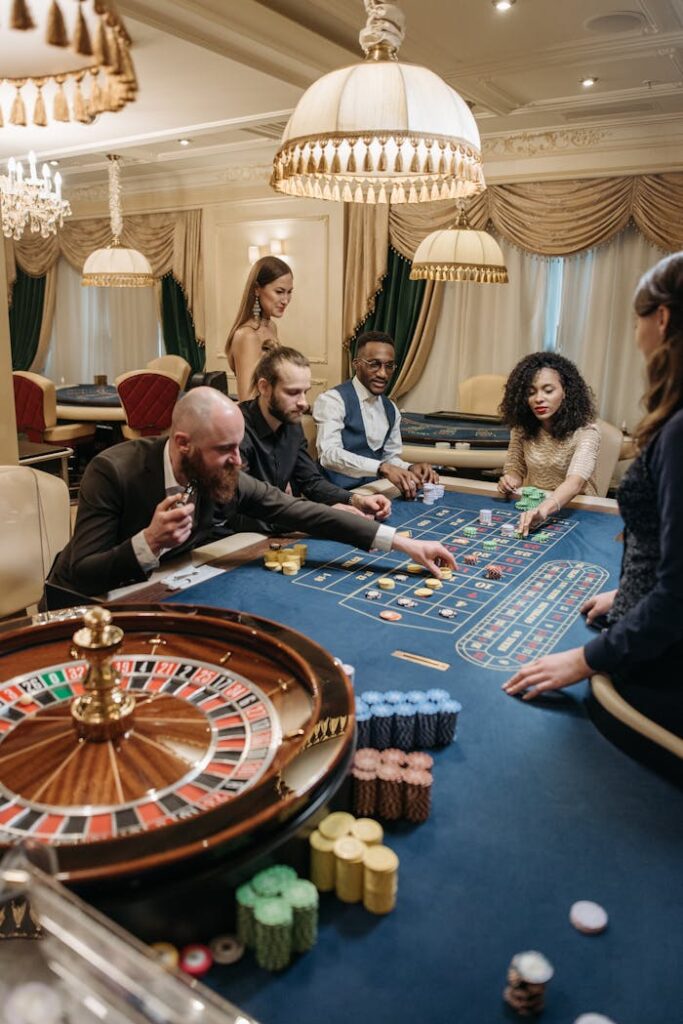 Dubibet Login Page | Register & Access Live Casino. A group of diverse adults playing roulette in an upscale, indoor casino setting.